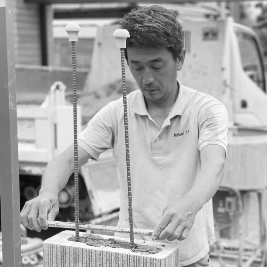 顧客宅の庭で丁寧に施工作業を行う中井庭園緑化の中井さん