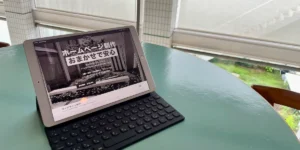 事務所のテーブルでタブレットとキーボードを使い、cuu design神戸の公式サイトを確認している様子