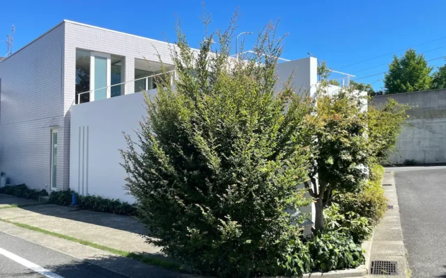 神戸・御影のクーデザイン神戸の事務所外観。青空の下、白い外壁と緑に囲まれたオフィス。